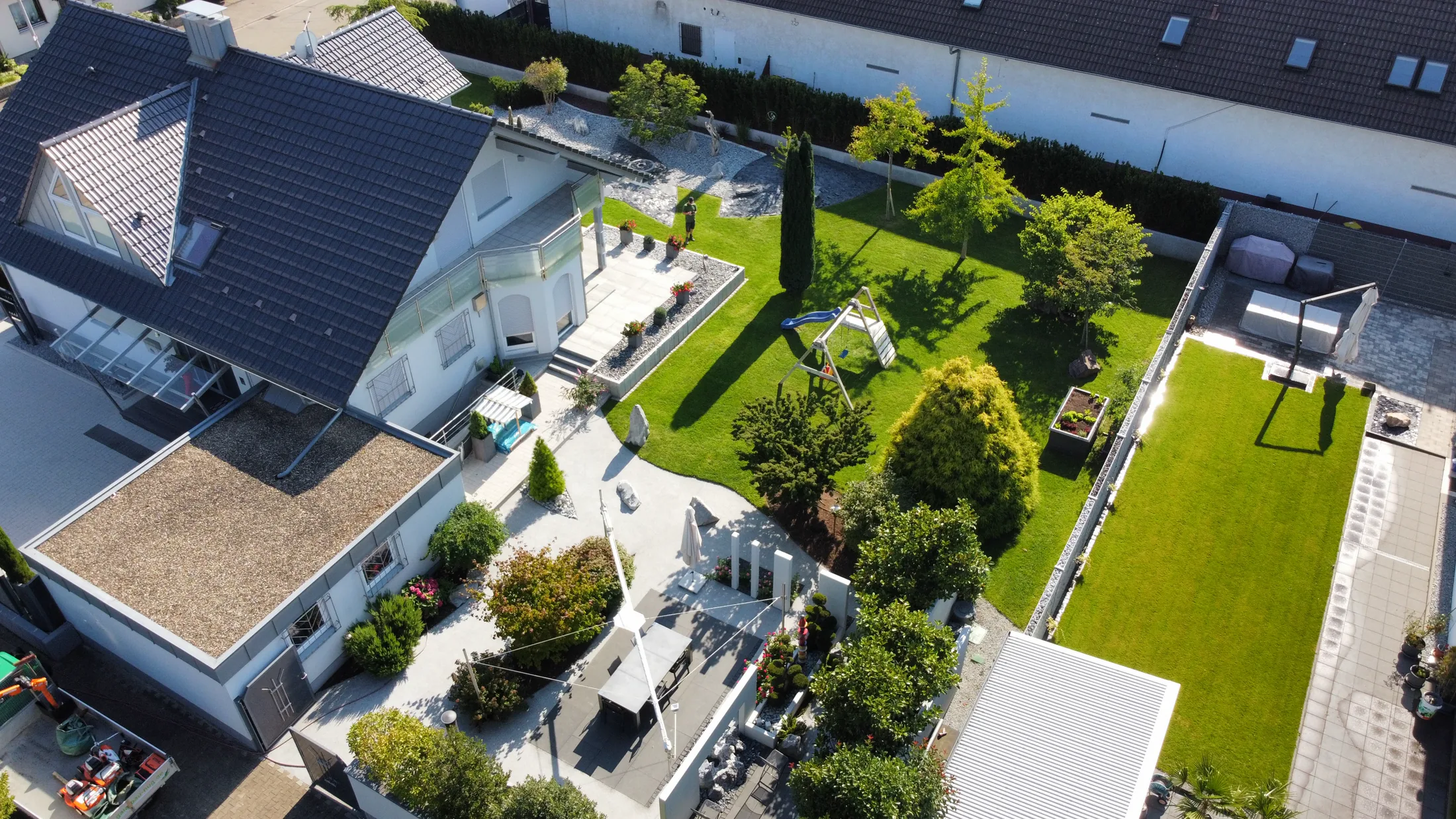 Umfangreiche Gartenanlage mit Rasenflächen, Natursteinwegen und klaren Pflanzbereichen